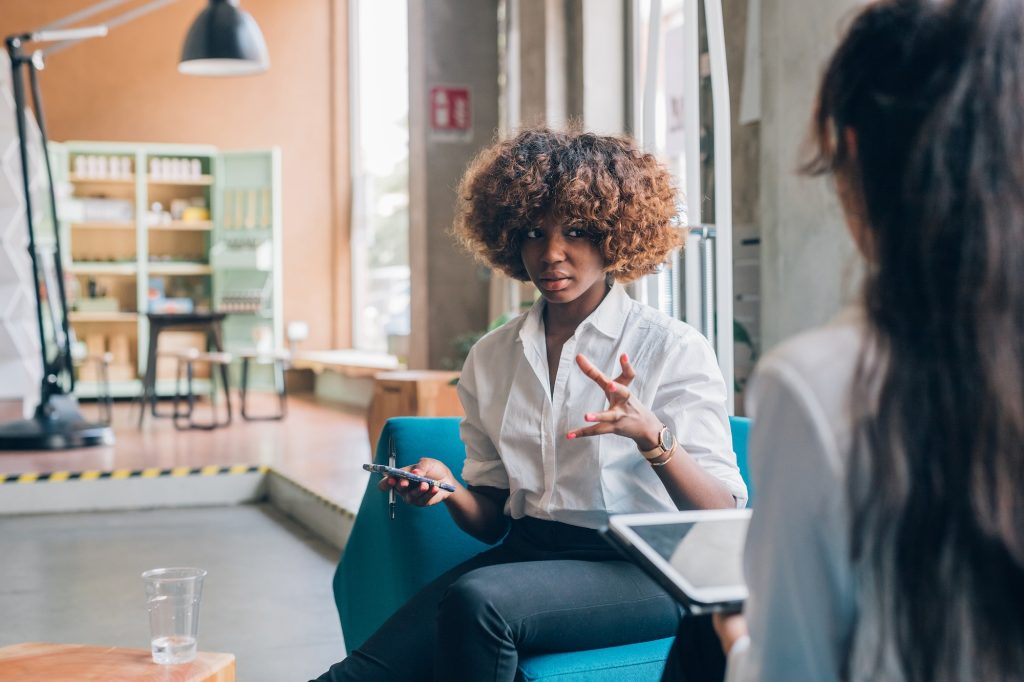 two multiracial students discussing project in co working office